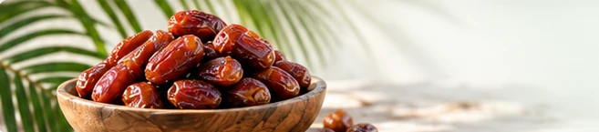 خرما در ظرف چوبی کنار برگ نخل